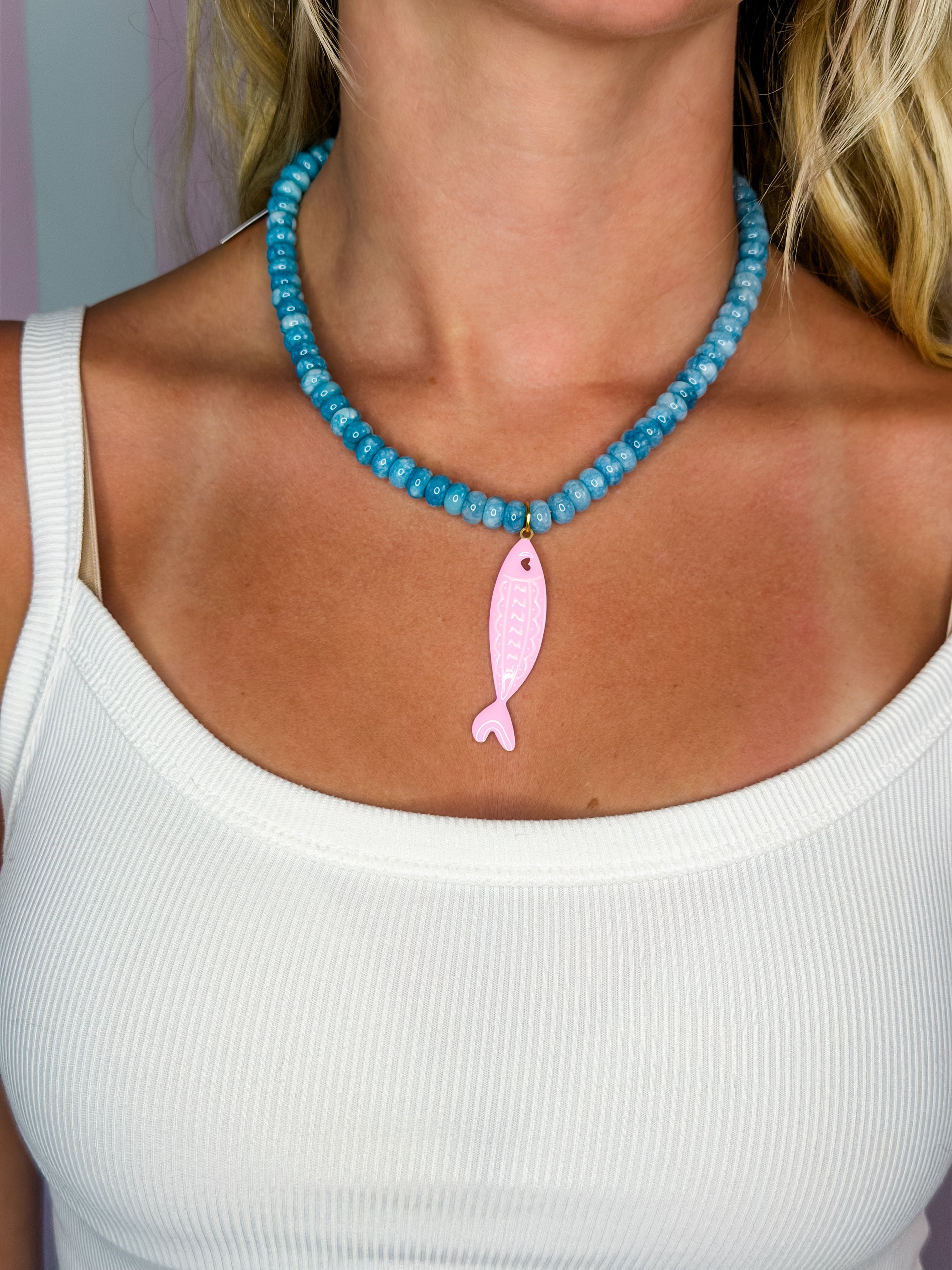 Blue beaded necklace with pink fish charm